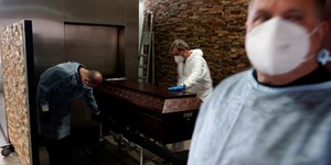 Εργαζόμενοι σε γραφείο τελετών στην Πορτογαλία ετοιμάζονται να βάλουν φέρετρο στο κρεματόριο