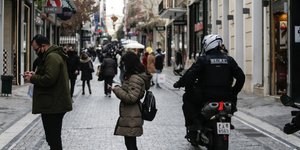 Κόσμος στέλνει SMS στο κινητό έξω από καταστήματα