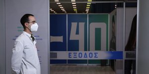 Γιατρός με μάσκα στέκεται προσοχή