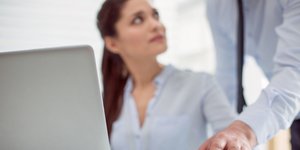 Ανδρικό χέρι αγγίζει γυναίκα κατά την διάρκεια εργασίας της