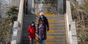 Γυναίκα κατεβαίνει σκαλιά με το παιδί της στη Κίνα