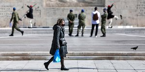 Γυναίκα περπατά μπροστά από την Βουλή