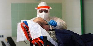 Νοσοκόμος φροντίζει ηλικιωμένο σε φορείο σε μονάδα της Πολωνίας