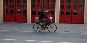 Άνδρας με ποδήλατο μπροστά από κόκκινη τζαμαρία στην Κύπρο