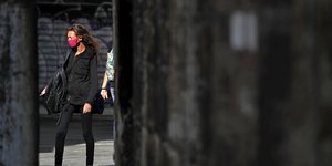 Μια γυναίκα με μάσκα για τον κορωνοϊό σε δρόμο της Αθήνας