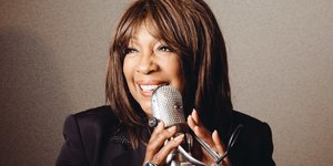 Η Μαίρη Γουίλσον κρατά μικρόφωνο