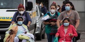 Νοσηλεύτριες μεταφέρουν ασθενείς σε αναπηρικό καροτσάκι