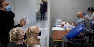 Μητέρα με τα παιδιά της φορούν μάσκα σε χώρο για τεστ κορωνοϊού