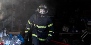 Πυροσβέστης με στολή και μάσκα σε επιχείρηση κατάσβεσης