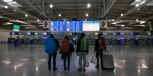 Ταξιδιώτες κοιτάζουν τον πίνακα αναχωρήσεων στο αεροδρόμιο των Σπατών