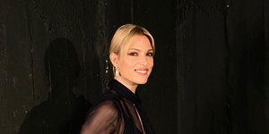 Η Βίκυ Καγιά με μαύρη μπλούζα και μαύρο παντελόνι χαμογελά