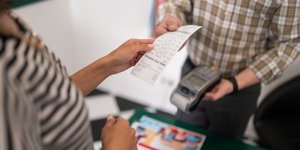 Γυναίκα παραλαμβάνει χάρτινη απόδειξη
