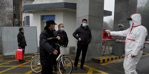 Γιατρός κάνει θερμομέτρηση σε Κινέζους