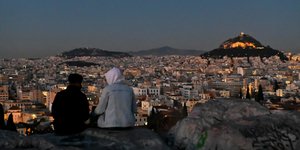 Νεαροί κάθονται κοιτάζοντας τον Λυκαβηττό
