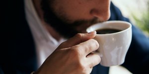 αντρας με μουσι πινει καφε