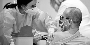 Γιατρός κάνει εμβόλιο κορωνοϊού σε ασθενή