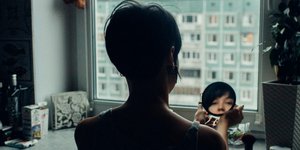 Γυναίκα κοιτάζει τον εαυτό της στον καθρέφτη