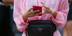 Γυναίκα κρατάει κινητό με πολλά δαχτυλίδια