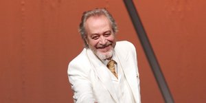 Ο Γρηγόρης Βαλτινός με λευκό κοστουμι