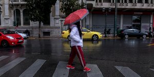 Γυναίκα με ομπρέλα στη βροχερή Αθήνα