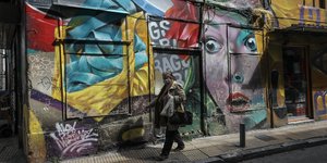 Μια γυναίκα περπατά μπροστά από γκράφιτι