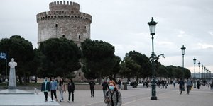 Πολίτες με μάσκες στην παραλία Θεσσαλονίκης με φόντο τον Λευκό Πύργο