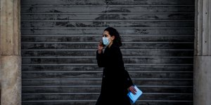 Μια γυναίκα περπατά μπροστά από κλειστό κατάστημα
