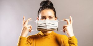 Μια γυναίκα βάζει μάσκα στο πρόσωπό της