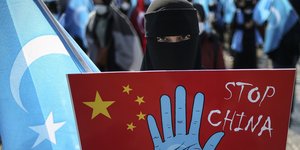 Γυναίκα με πλακάτ κατά της Κίνας για τους Ουιγούρους