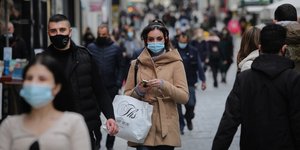 Γυναίκα περπατά φορώντας ακουστικά και μάσκα