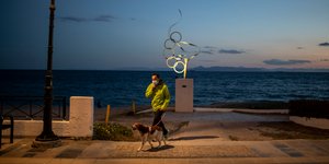 Ανδρας με μάσκα για τον κορωνοϊό βγάζει βόλτα τον σκύλο του