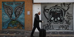 Ανδρας περπατά σέρνοντας βαλίτσα