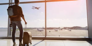 Ενας νεαρός με τη βαλίτσα του στο αεροδρόμιο