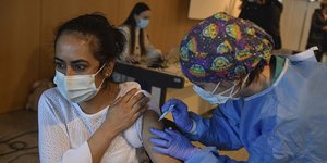 Γυναίκα εμβολιάζεται από υγειονομικό