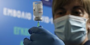 γυναίκα νοσηλεύτρια κρατά εμβόλιο για κορωνοϊό