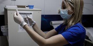 γυναίκα νοσοκόμα με εμβόλιο για κορωνοϊό σε εμβολιαστικό κέντρο