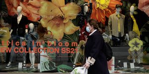 Γυναίκα περπατά έξω από βιτρίνα καταστήματος