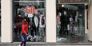 Γυναίκα έξω από βιτρίνα καταστήματος