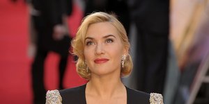 Η Κέιτ Γουίνσλετ σε κόκκινο χαλί κοιτάζει ψηλά