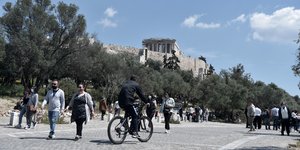 Κόσμος και ένας ποδηλάτης κάνουν βόλτα κοντά στην Ακρόπολη