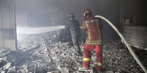 πυροσβέστες σβήνουν φωτιά σε κτίριο