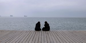 Γυναίκες κάθονται σε προβλήτα στην Θεσσαλονίκη