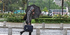 Ανδρας περπατά με ομπρέλα στη Θεσσαλονίκη
