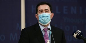 Ο Νότης Μηταράκης με μάσκα, γραβάτα και κοστούμι