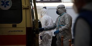 νοσηλευτής με ιατρική στολή έξω από ασθενοφόρο