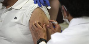 νοησλευτής κάνει εμβόλιο για κορωονϊό σε μπράτσο γυναίκας