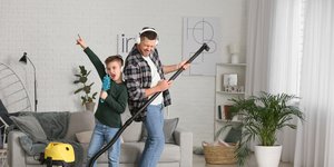 άνδρας με αγοράκι καθαρίζουν με ηλεκτρική σκούπα