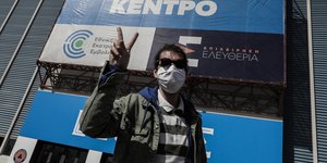 νεαρός άνδρας κάνει το σήμα την νίκης έξω από εμβολιαστικό κέντρο