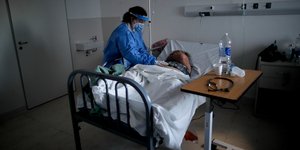 Γιατρός εξετάζει ασθενή με κορωνοϊό σε δωμάτιο νοσοκομείου στην Αργεντινή