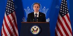 Ο υπουργός Εξωτερικών των ΗΠΑ,  Αντονι Μπλίνκεν, μιλάει σε βήμα με δυο αμερικανικές σημαίες στο φόντο